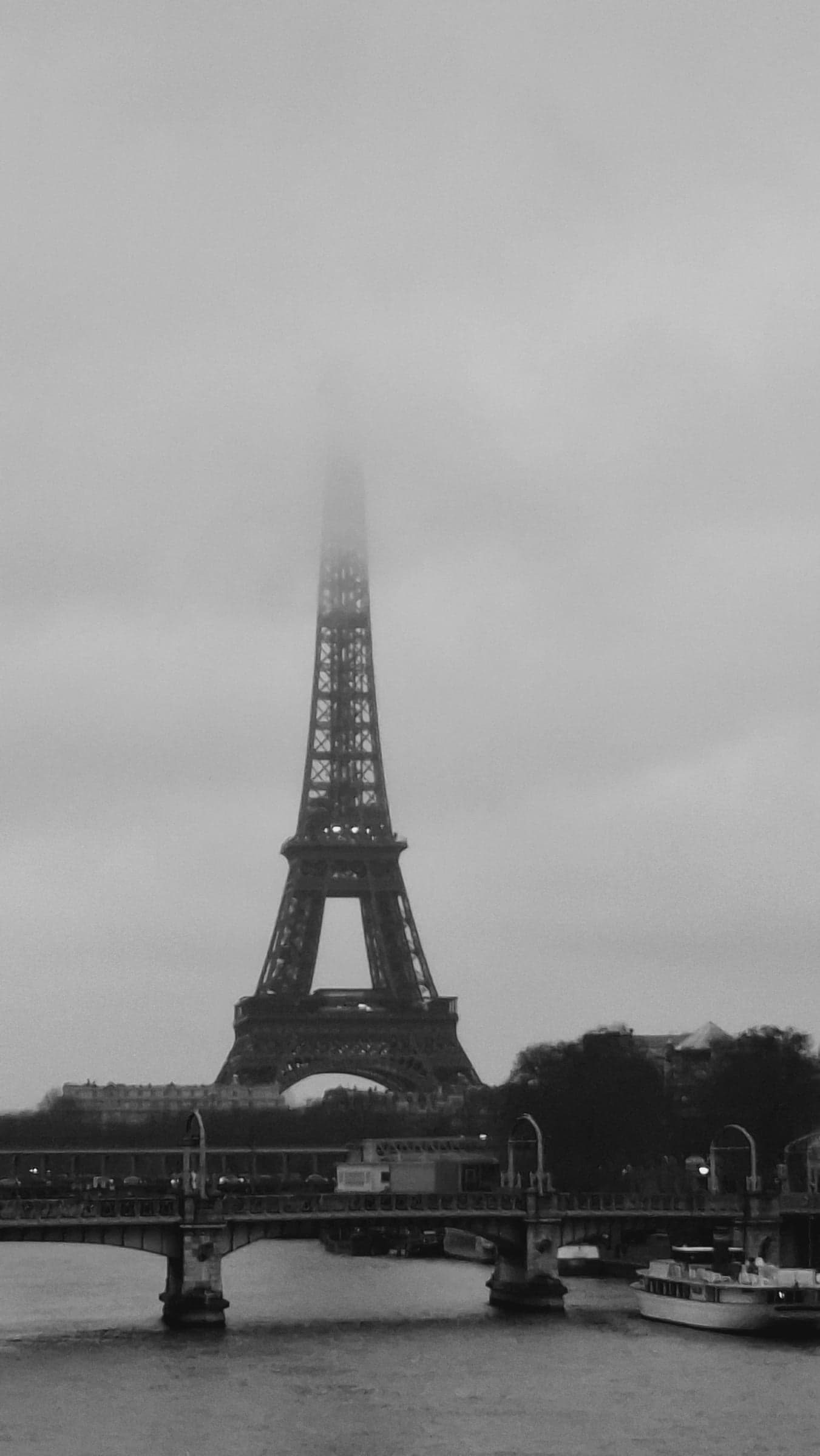 black and white: the eiffel tower fading into fog over the river