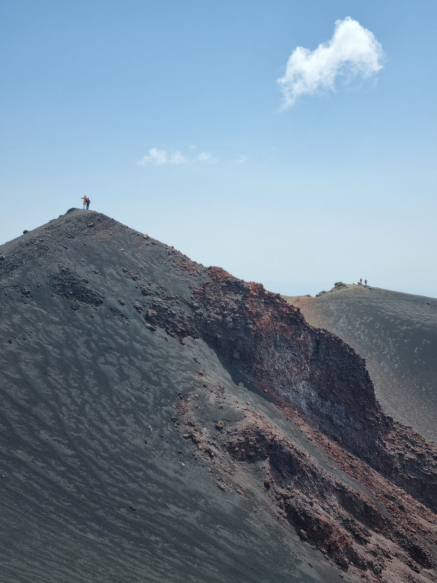 a figure standing on top of a volcanic ridge