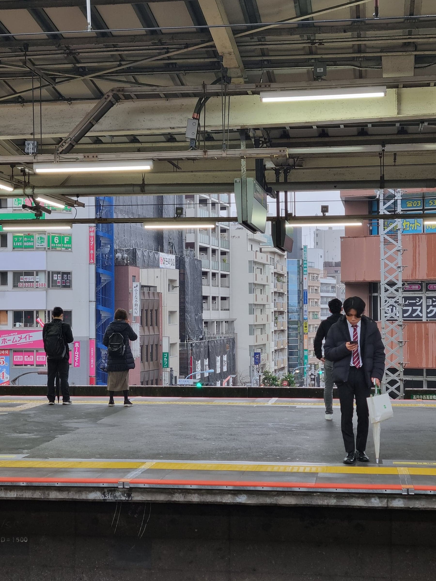 people waiting on an elevated train platform